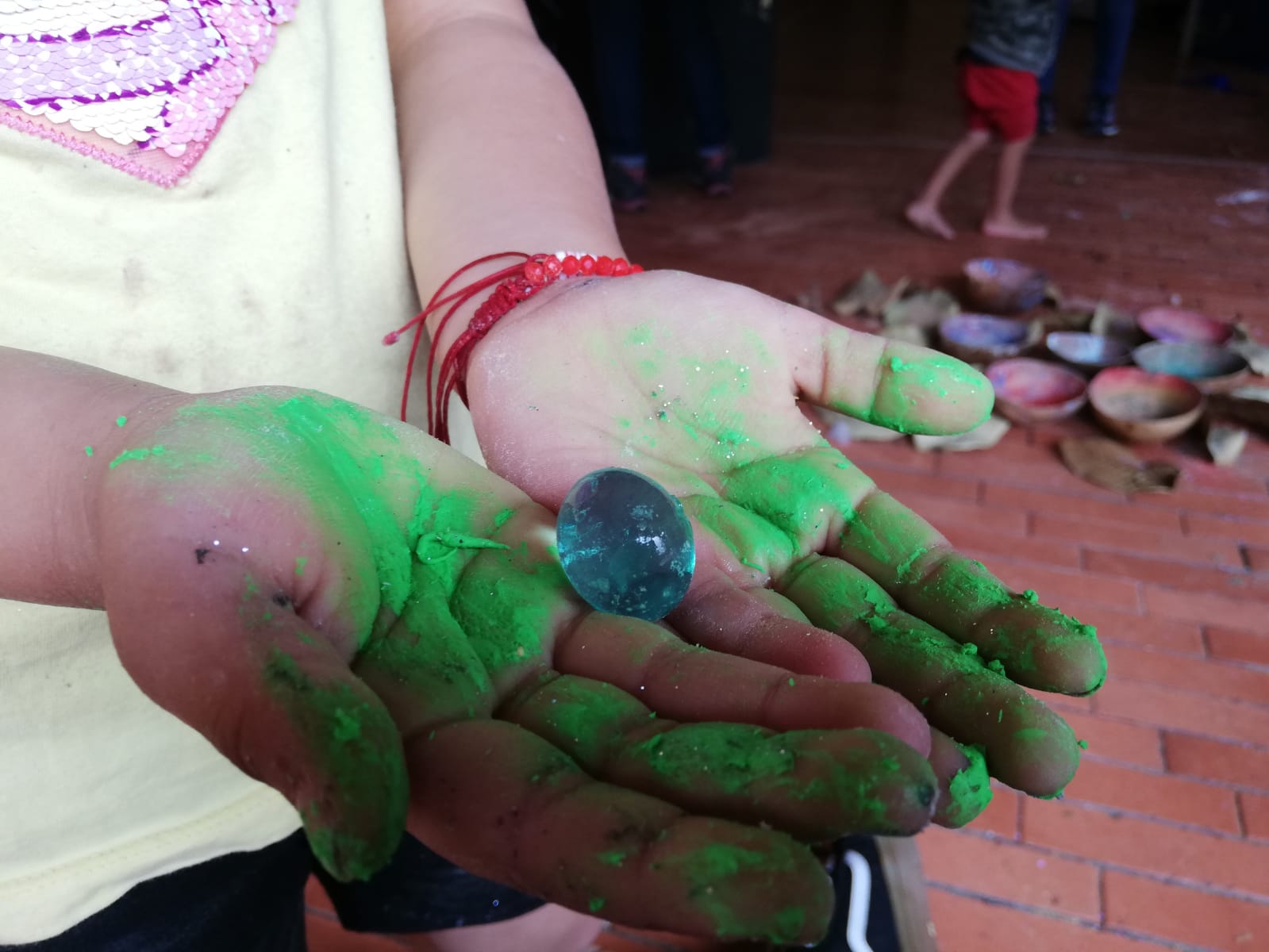 Persona con las manos pintadas de tempera verde y azul 