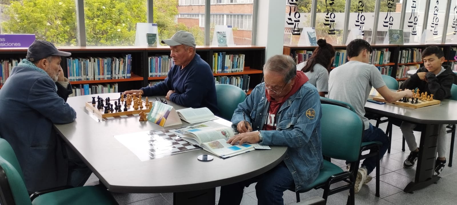 Adultos juegan ajedrez en la biblioteca