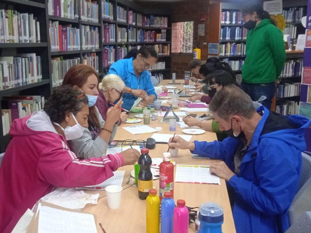 Adultos participando de actividad de la biblioteca con materiales artísticos
