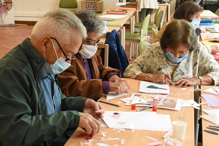 Adultos mayores participando de actividad artística en la biblioteca