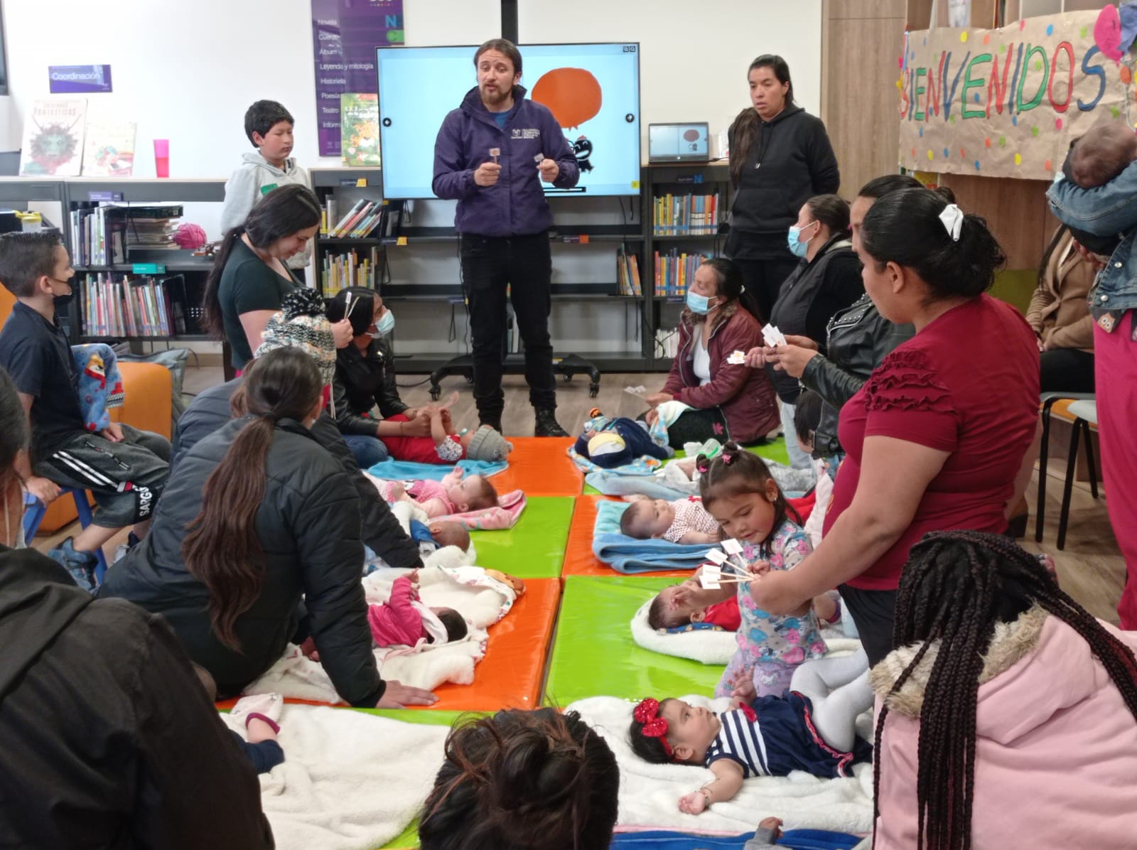 bebés y acompañantes participan de actividad en la biblioteca