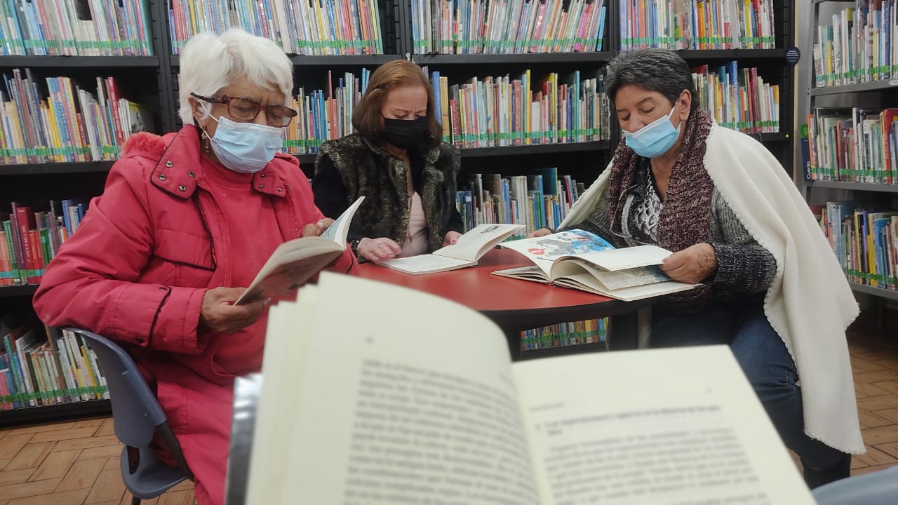 Adultos mayores leyendo en biblioteca