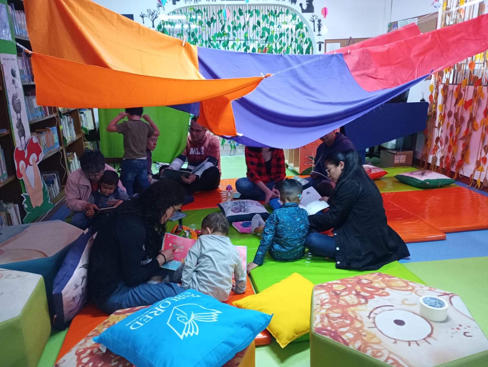 Bebés y acompañantes participando de actividad en la biblioteca