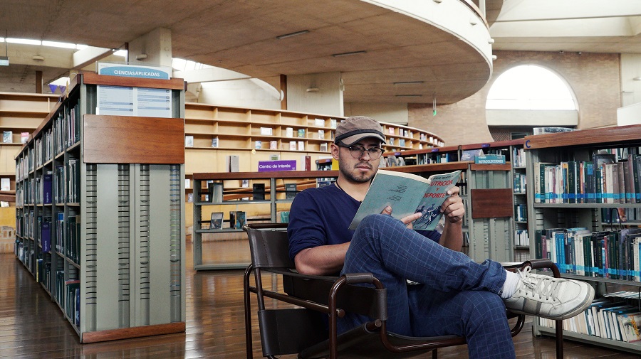 Hombre leyendo en biblioteca