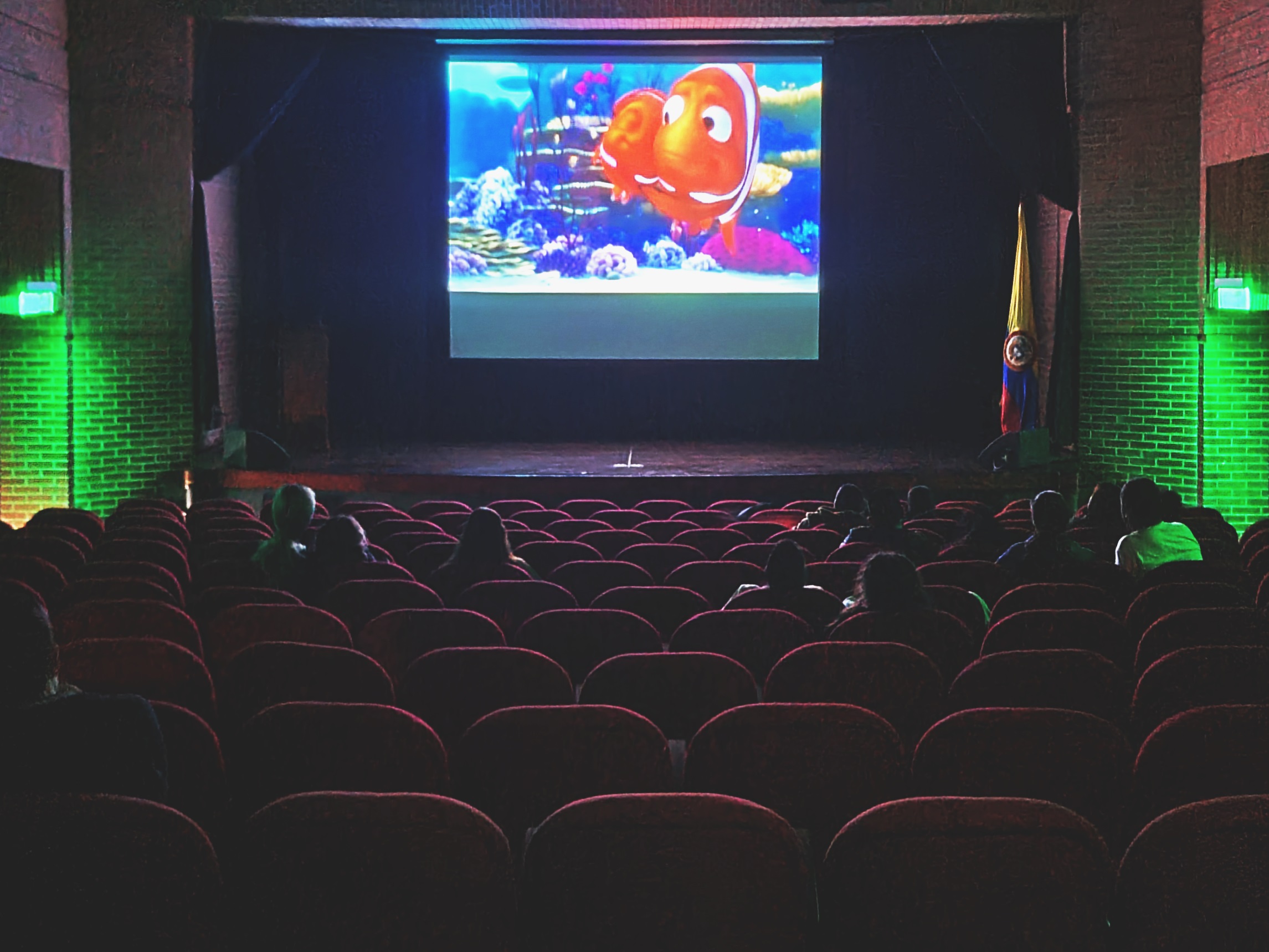 sala de cine con familias viendo una película animada.