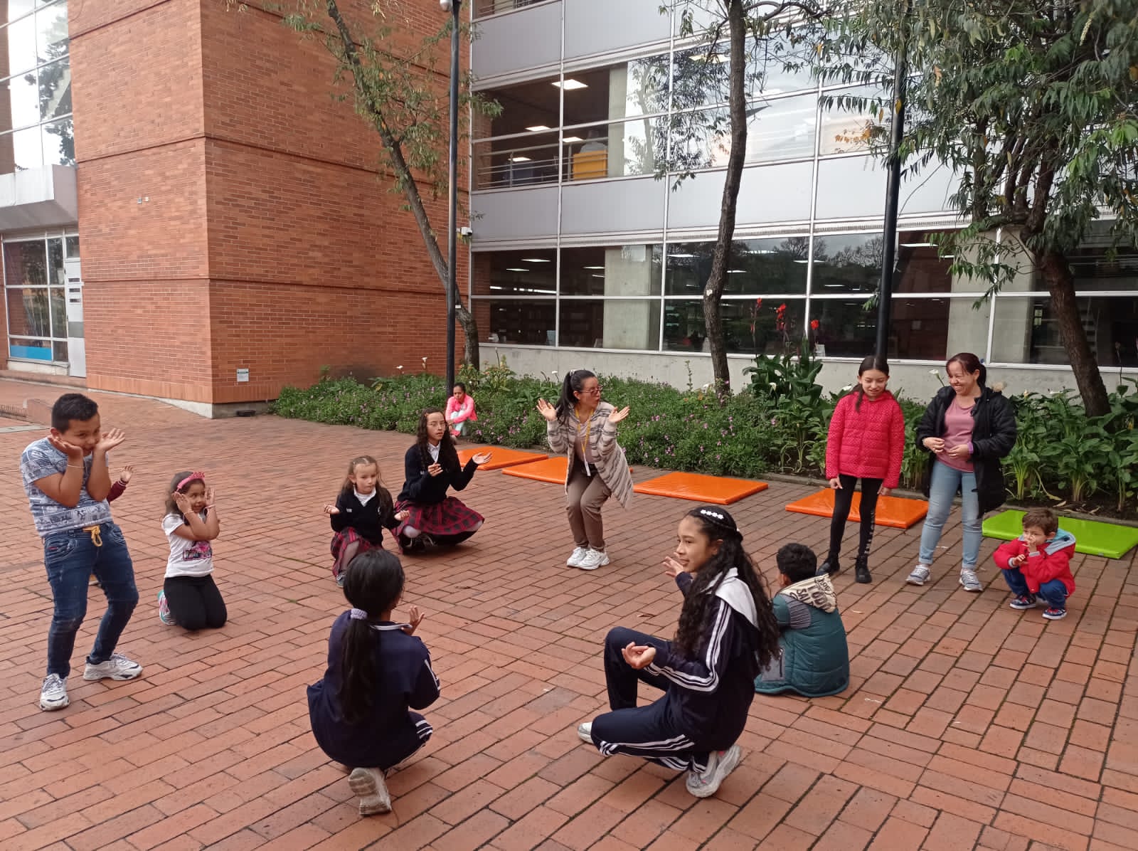 niños y niñas jugando y haciendo actividad física al aire libre acompañados y guiados por una profesora