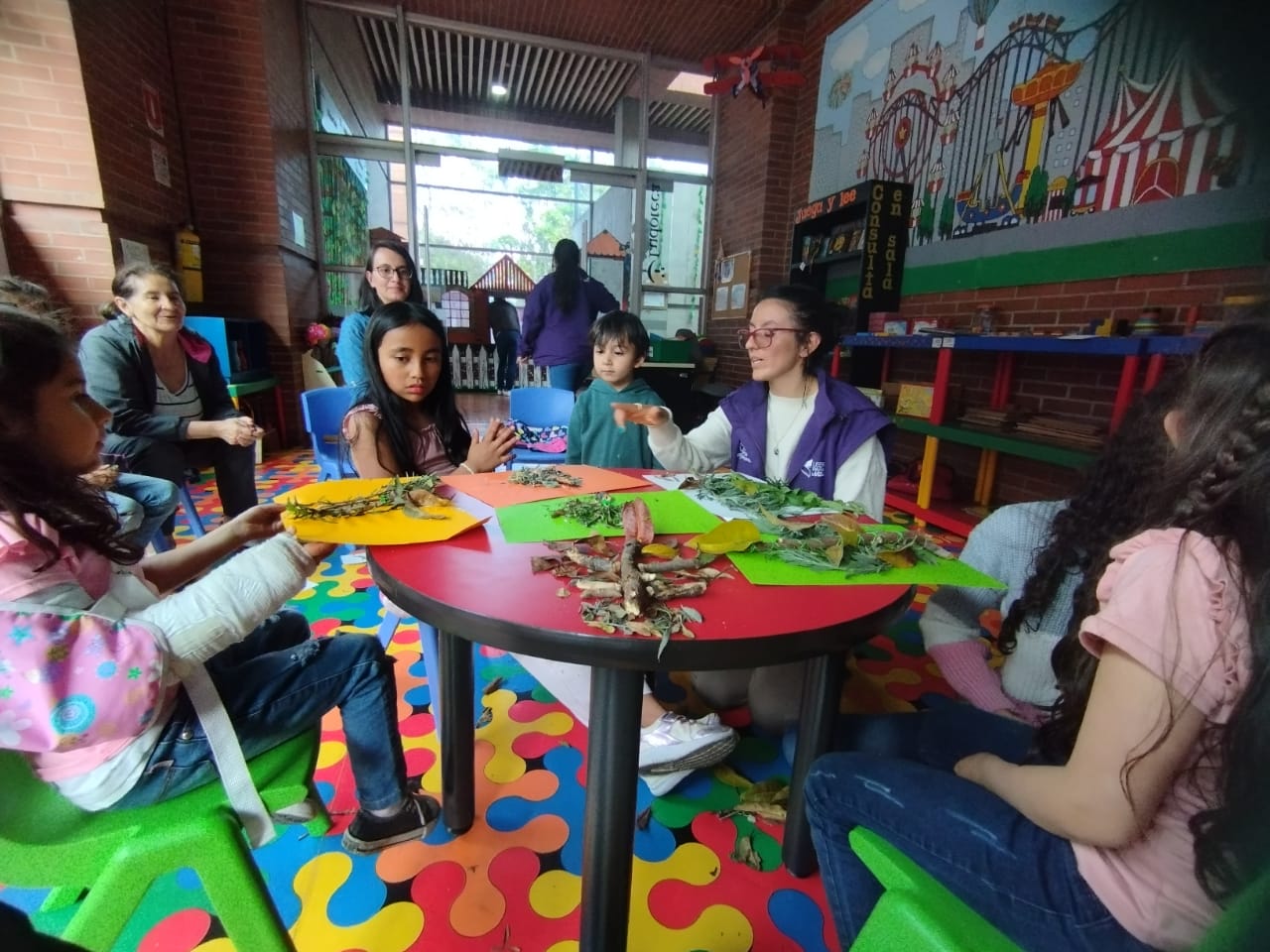 Niños y niñas participando de actividad en la biblioteca con elementos de la naturaleza