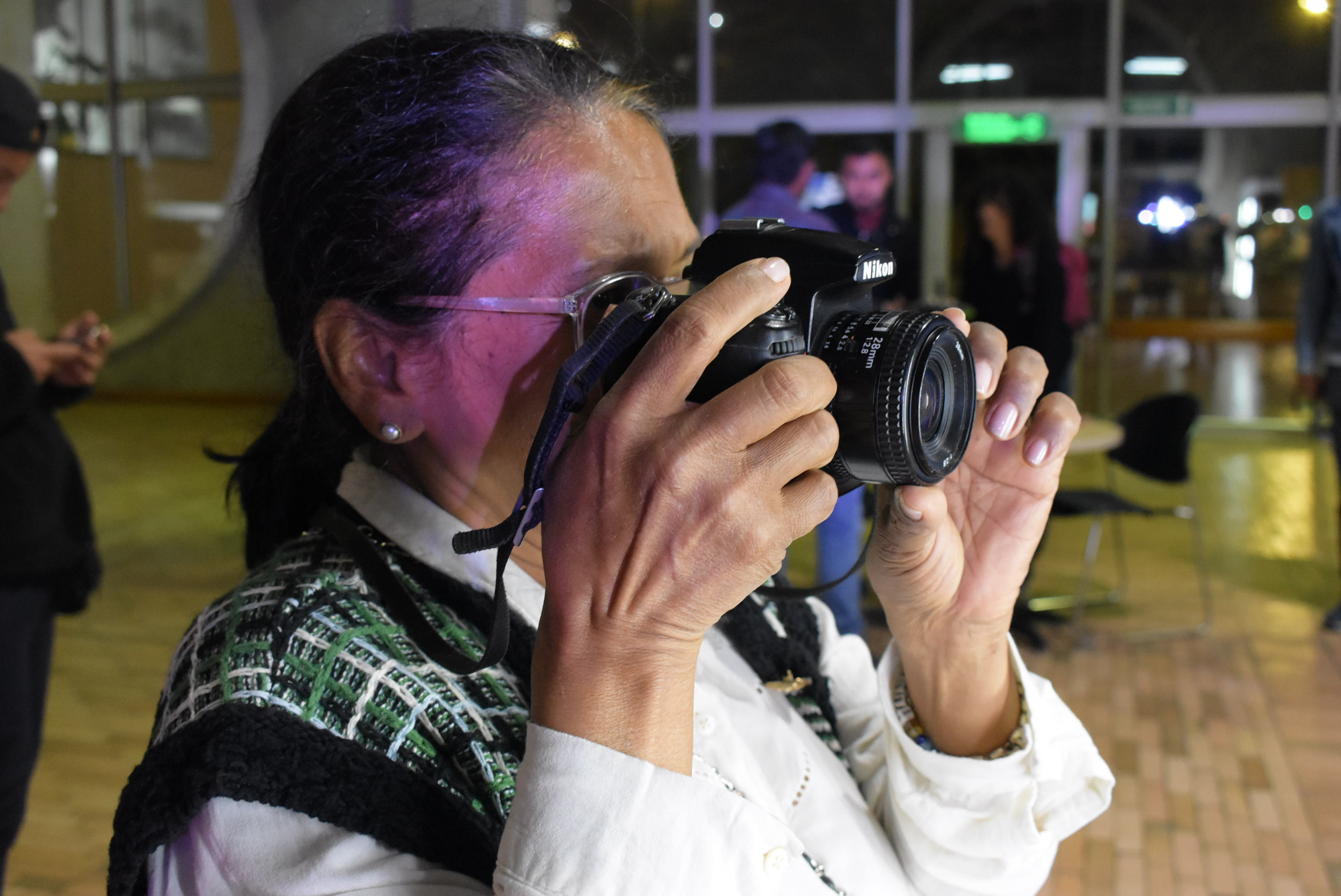 Mujer mayor tomando una fotografía con una cámara profesional