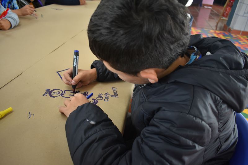 niño dibujando con un marcador azul