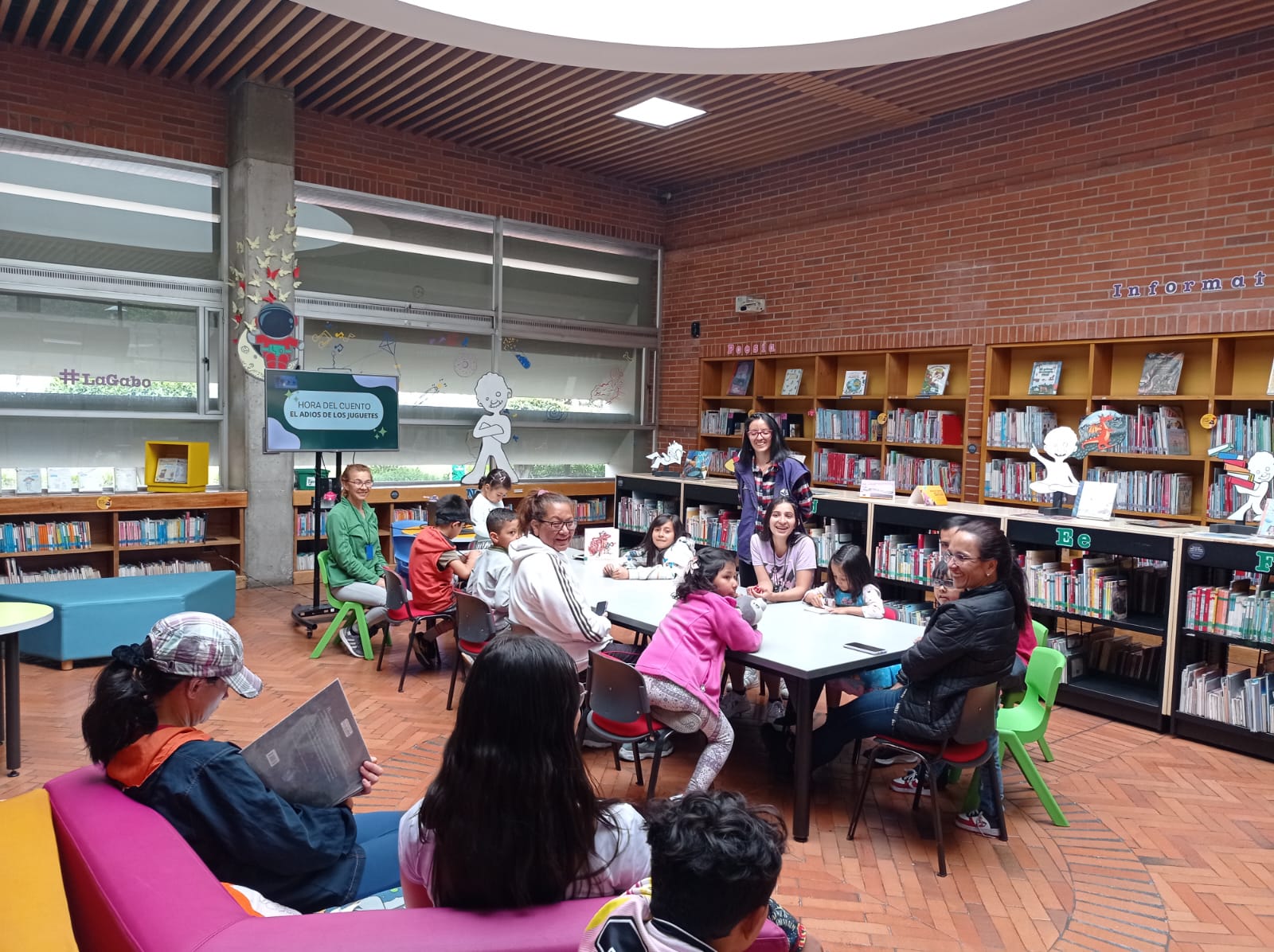grupos de niños y adultos en medio de una sesión de lectura grupal