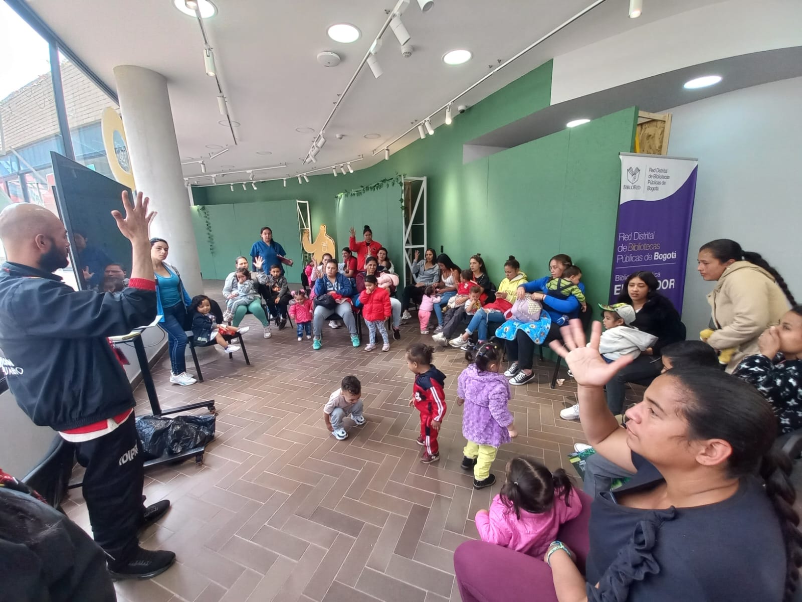 Niñas, niños y acompañantes, participan de actividad en la biblioteca