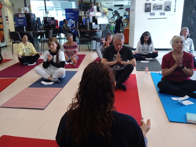 grupo de adultos mayores en medio de una sesión de yoga