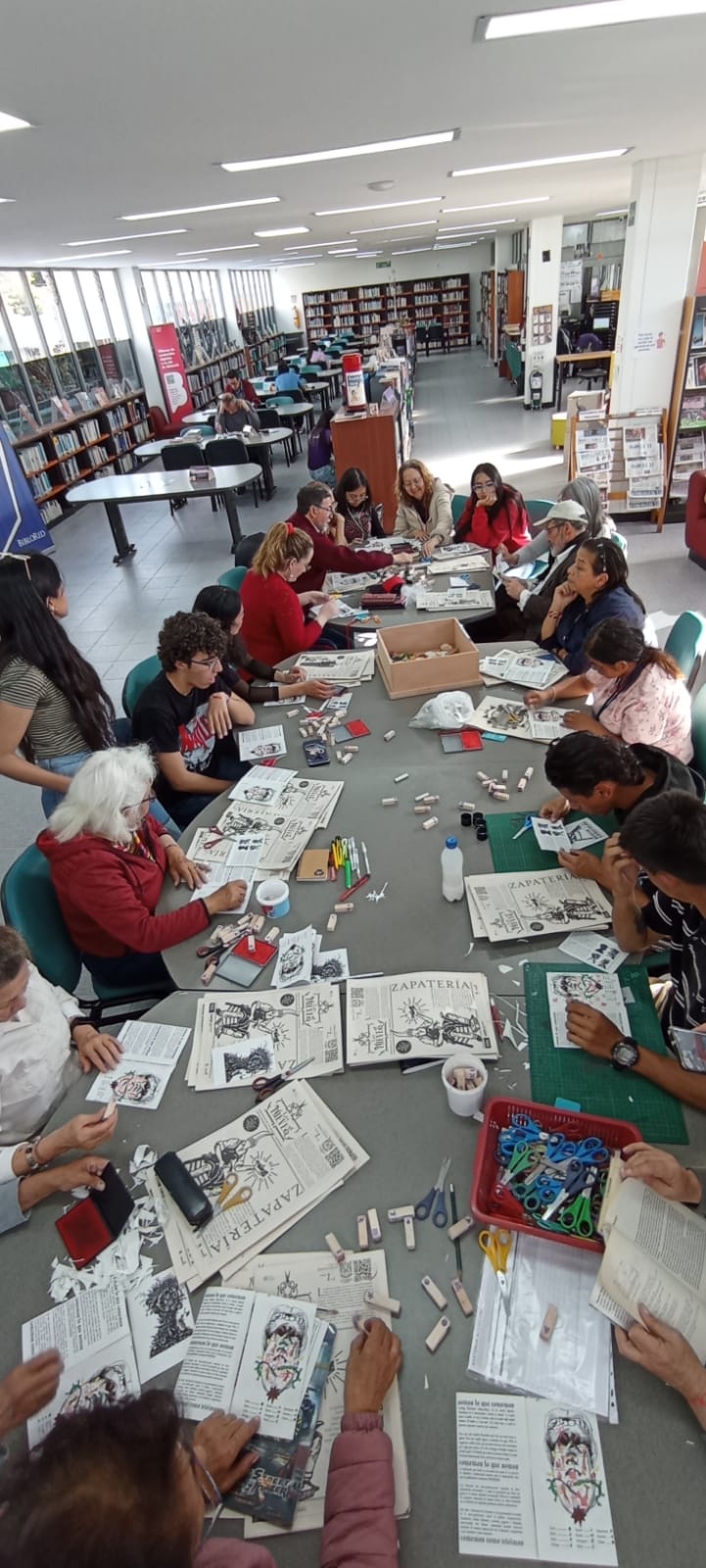 grupo de adultos mayores en medio de un taller de manualidades en donde están cortando revistas